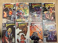 Photo showing 8 different issues of Supergirl comics neatly arranged side by side, highlighting cover art with characters and titles clearly visible