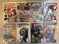 Lot of 8 DC Supergirl comics bagged and boarded, showing front covers arranged in two rows of four against wooden floor background.