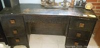Photo of front of the desk showing three drawers on the left side with square brass handles and part of the central kneehole area.