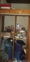 Wooden shelving unit stocked with plastic totes, boxes, and assorted Christmas and holiday decorations.