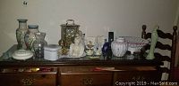 Front view showing anniversary clock, multiple vases, glass vase, figurines, tins, and ruffled rim bowl arranged on a table.
