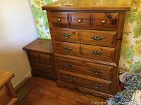 Photo showing the wooden chest of drawers and nightstand side by side, highlighting the wood finish and drawer handles.