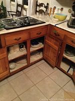 Corner kitchen cabinetry with some dishes and appliances stored on shelves and counter.