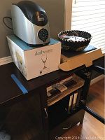 Cooper Cooler wine chiller on top of a box with a fruit bowl next to it on a cabinet