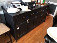 Front and side angled view of the custom-built Italian buffet with dark finish, showing drawer handles and cabinet doors.