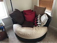 Large round chair with multiple throw pillows placed on seating surface