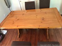 Top down view of rectangular wooden table showing natural wood finish and wood knots.