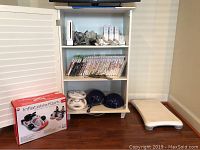Shelf view showing console, controllers, sensor bar, wheels, helmets, inflatable kart box and balance board