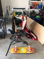 Photo showing bike rack, bike pump, go-kart jumpsuits, wire storage cubes, and skateboard on floor