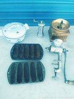 Photo showing all vintage kitchen items together: enameled pot, cast iron cornbread pans, meat grinder, coffee grinder, and pepper mill.