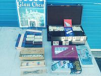 Full lot overview with all items: Tile Rummy case open showing tiles and racks, boxed dominoes, poker chips in original boxes, pick-up sticks, and glass chess set box.