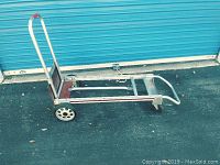 Side view of adjustable wheeled cart showing metal frame, rear wheels and handle.