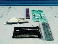 Complete lot with multiple pens, pencils, refills, and original packaging on white surface.