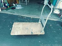Top-down angled view of push cart showing wooden platform and metal handle.