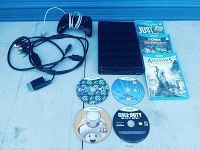 Nintendo Wii U console, controller, AV cords, 7 game discs and cases laid on flat surface