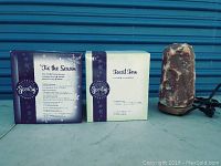 Photo showing two boxed Scentsy aroma warmers labeled 'Tis the Season' and 'Fossil Fern' along with a Himalayan salt lamp.
