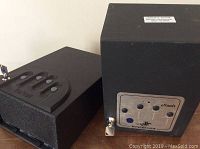 Two Winchester eVault safes side by side, showing front locking panels and keys in locks.
