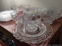 Photo showing three cups, three saucers and three lunch plates on a wooden surface for visual identification of the set design and condition.