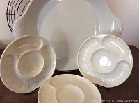 All items together including four artichoke plates, large serving platter, and wire trivet