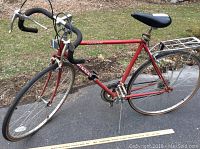 Full side view of the red Pinnacle Free Spirit bicycle showing frame, handlebars, tires, and rear rack