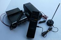 Two mobile CB radios and accessories: Radio Shack TRC-460 handheld radio, base unit, magnetic antenna mount with antenna, and Johnson Messenger 4140 with microphone and wiring.