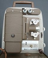 Top view of Bell & Howell projector showing textured finish, lens, reels, controls, and handle.