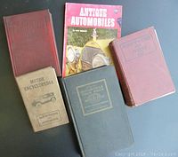 Five vintage automobile books arranged together showing front covers and spines.