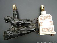 Two vintage lamps, one black panther-shaped ceramic base and one white floral ceramic base, cords visible, no shades included.