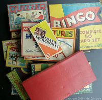 Top view of the assortment of vintage games including Quizzer, Bingo, That's Incredible, and more in their original boxes.