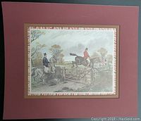 Overall view of the matted equestrian print showing two riders on horses jumping a gate, with a reddish-brown mat and narrow decorative border.