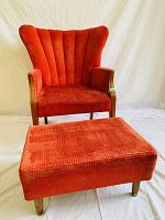 Front view of red wingback chair with matching footstool showing overall design and upholstery condition