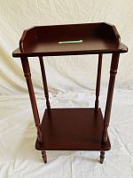Front view of the wooden two-tier table/stand showing structure and finish