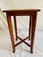 Side view of wooden table/stand showing four straight legs and crossbar support frame