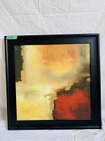 Framed square abstract art with warm color blocks and black frame.