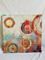 Front view of abstract canvas showing concentric circle patterns in warm, earthy colors.