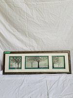 Full view of a large horizontal framed artwork containing three side-by-side illustrations of bare trees within bordered sections.