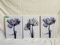 Three canvas art pieces photographed side by side against a white fabric background, showing detailed black and white floral images.