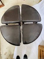 Photo of four pie-shaped stools arranged in a circle forming a near-complete circle from the seats.
