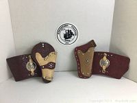 Photo showing the pair of 1950s child's western cowboy holsters and matching gauntlets in brown and tan faux leather with silver-tone studs and conchos on a white background.