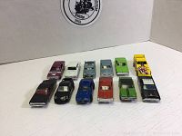 Overhead view of all 12 Hot Wheels cars lined up in two rows, showing colors and condition.