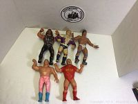 Photo showing five vintage LJN WWF rubber wrestler figures in varied poses and outfits against white background.