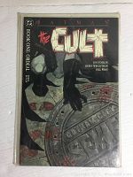 Front cover of Batman The Cult Book One comic showing Batman over Gotham City sewer manhole cover with title and credits.