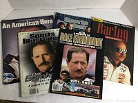 Lot of 5 magazines featuring Dale Earnhardt and NASCAR themes arranged on white surface including Sports Illustrated and Beckett Racing covers.