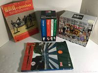 Shows four Beatles-related items: Beatles Combo book, Beatles Box Set with DVDs for each member, A Hard Day's Night DVD, and Beatles memorabilia photo book.