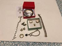 Overview of entire jewelry lot on white surface