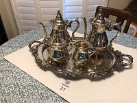 Full view of silver plated tea service set including two pots, cream pitcher, sugar bowl on large ornate tray