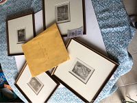 Four framed drawings and manila envelope arranged on patterned surface