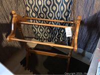 Wooden blanket rack in natural wood color, showing turned posts and horizontal bars.