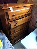 Full view of the oak chest of drawers showing four drawers, with one slightly open to show drawer glide feature.