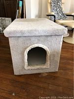 Front view of litter box enclosure showing arched entrance and carpet covering